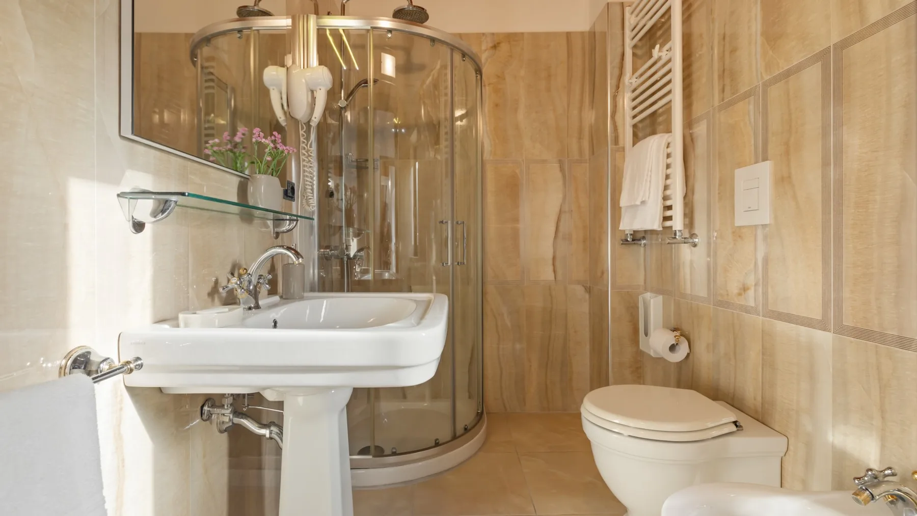 A tiled bathroom with a sink, shower, and toilet.