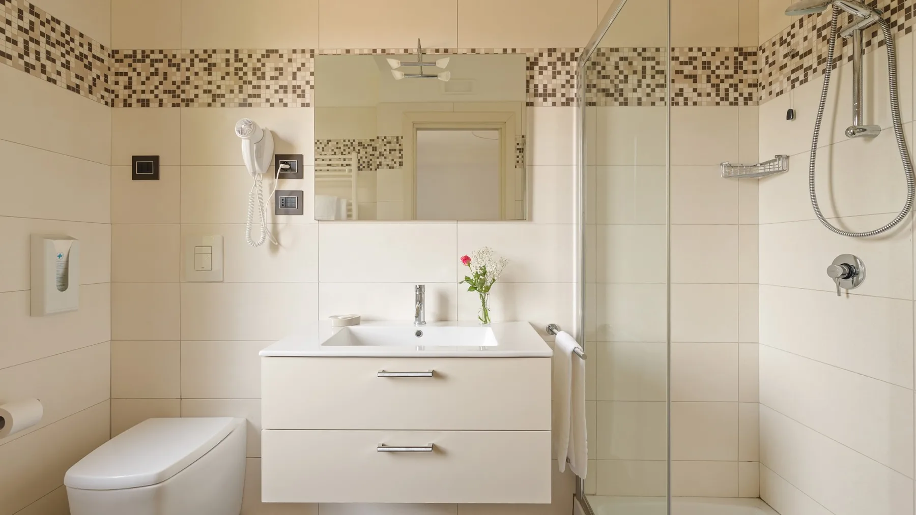 A tiled bathroom with a sink, wall mirror, and shower.