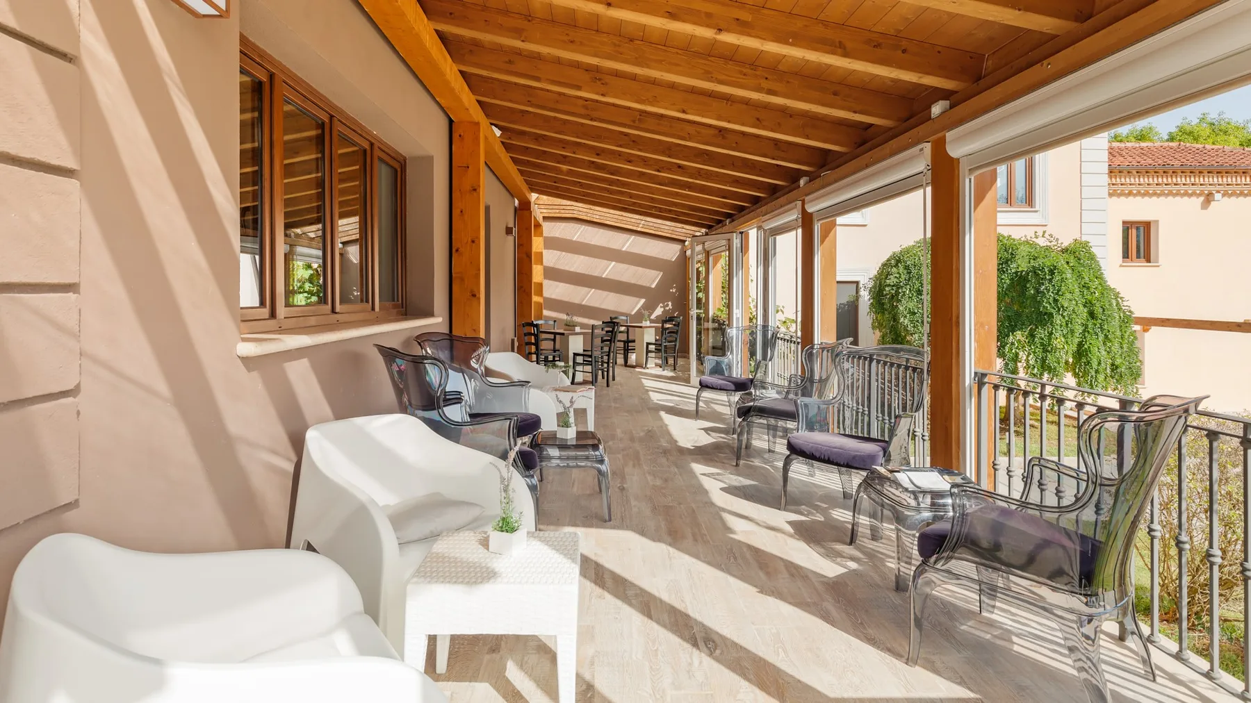 A covered outdoor terrace with seating and a wooden overhead canopy.