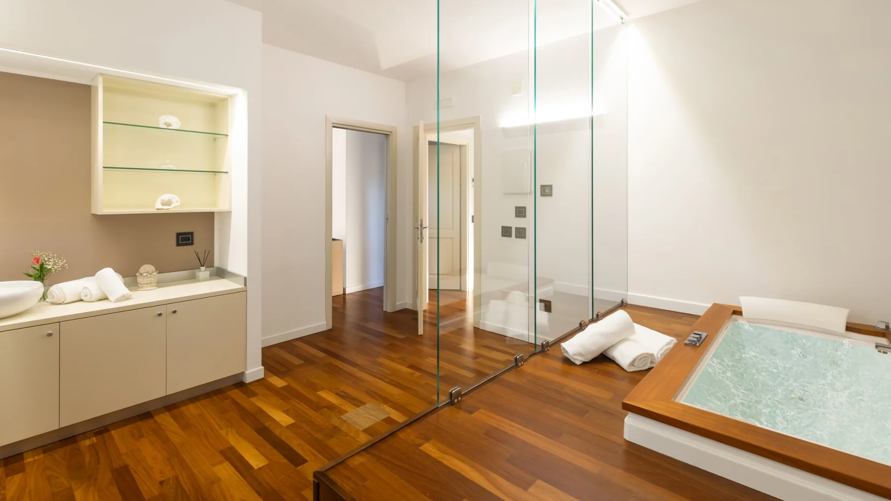 A bright bathroom with a glass shower and a built-in soaking tub.