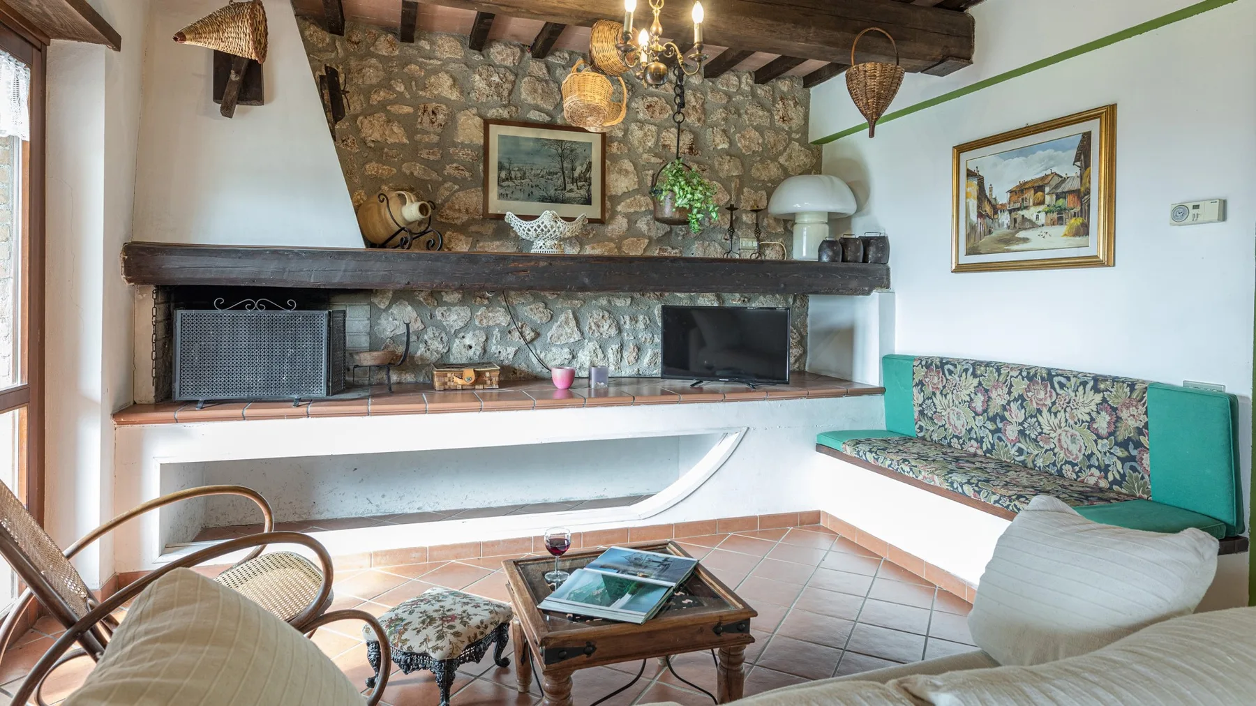 Un salón rústico con chimenea de piedra, asientos empotrados y una mesa baja de madera.
