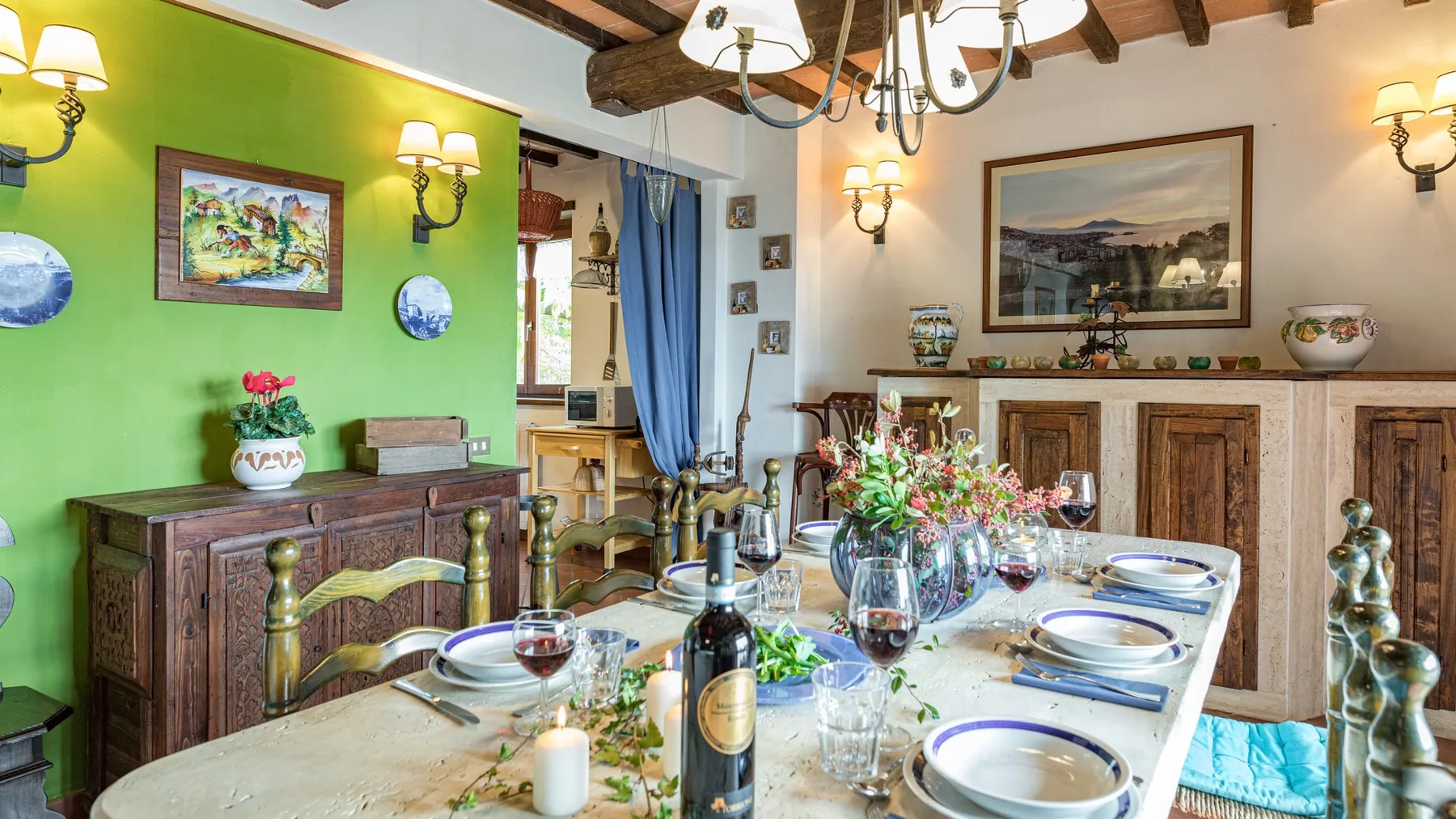 Un comedor con una mesa larga preparada con platos y flores.