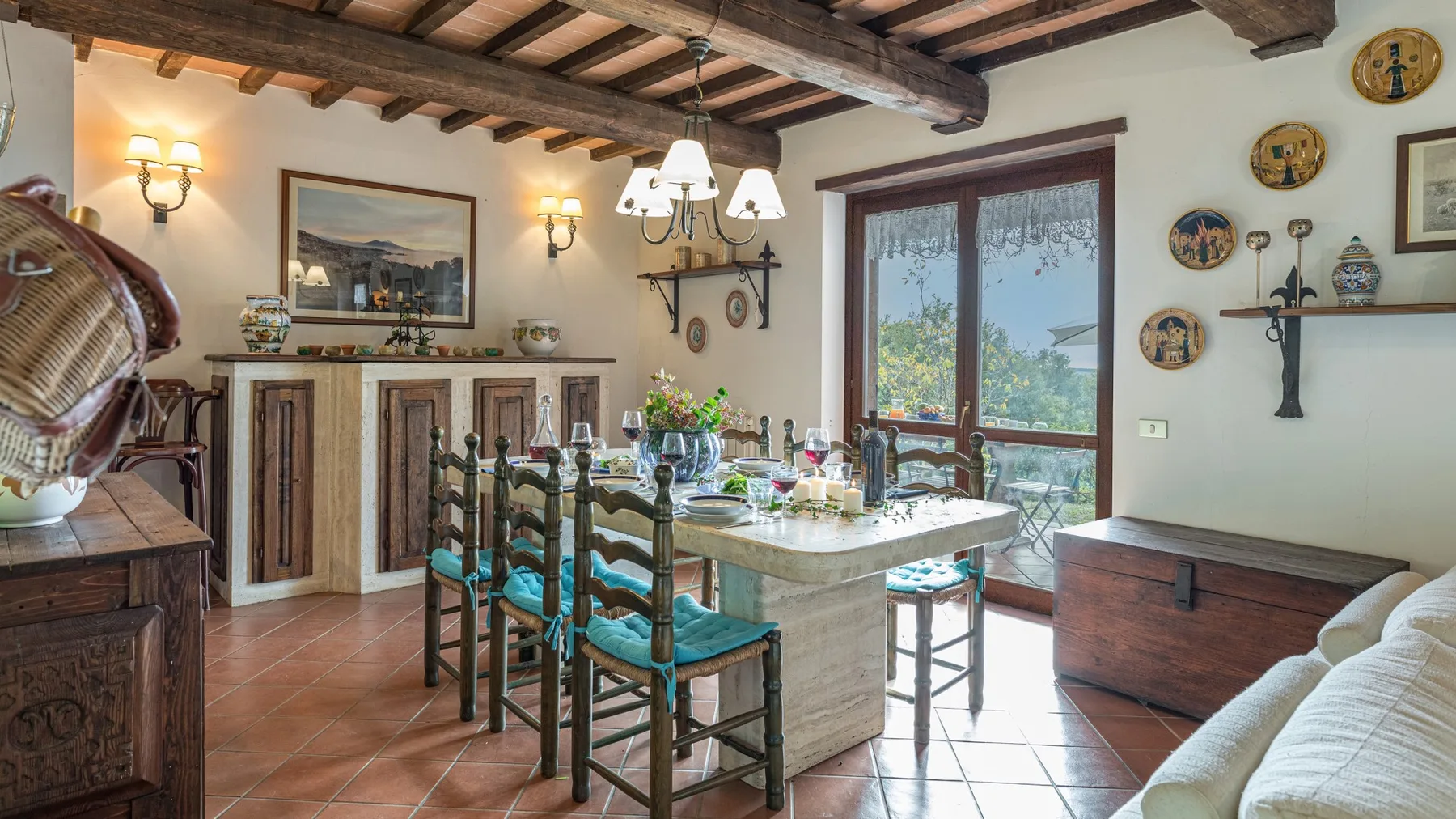 Un comedor con una mesa larga, sillas y grandes puertas de vidrio.