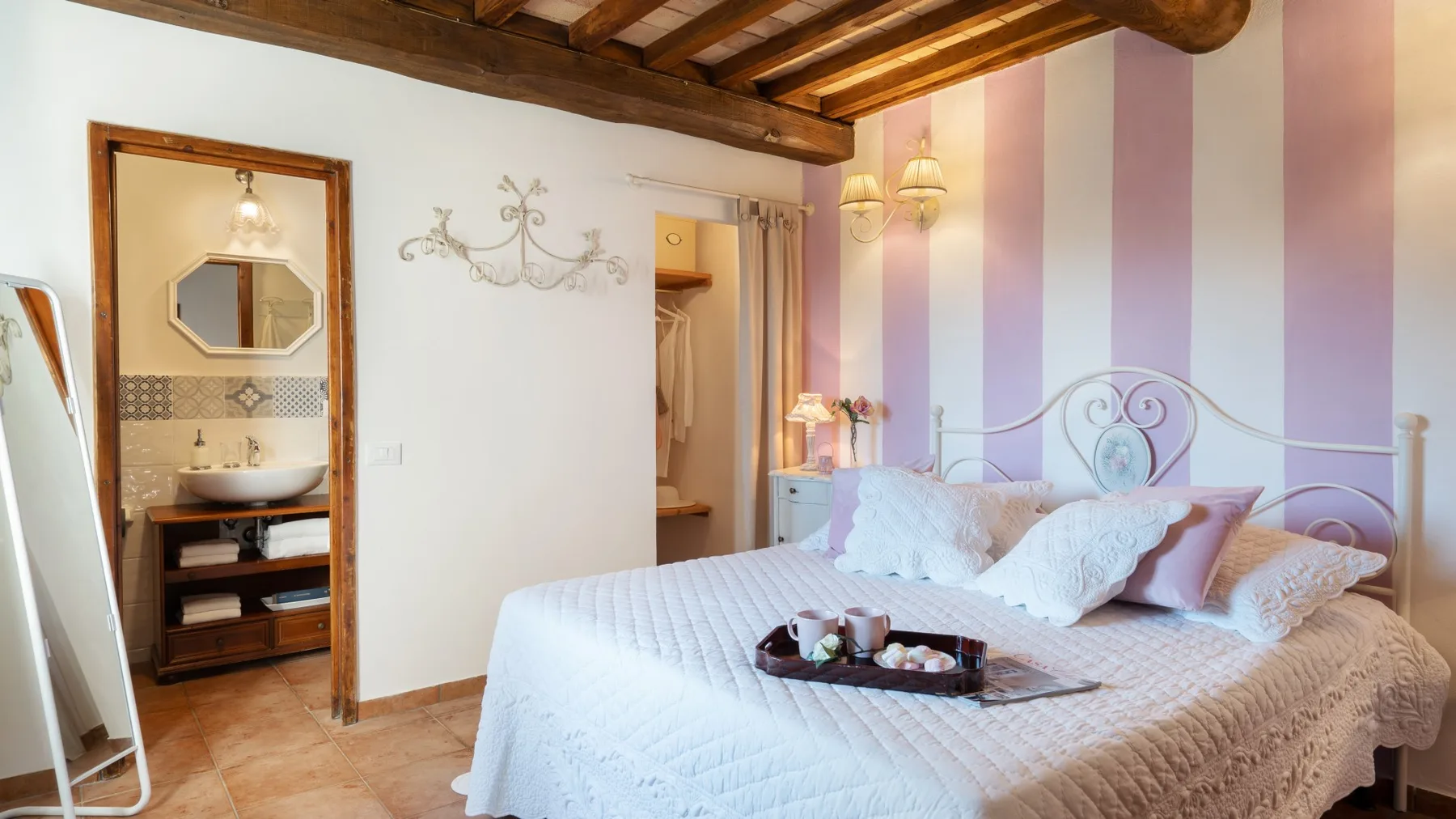 Un dormitorio con una cama bajo vigas de madera expuestas.