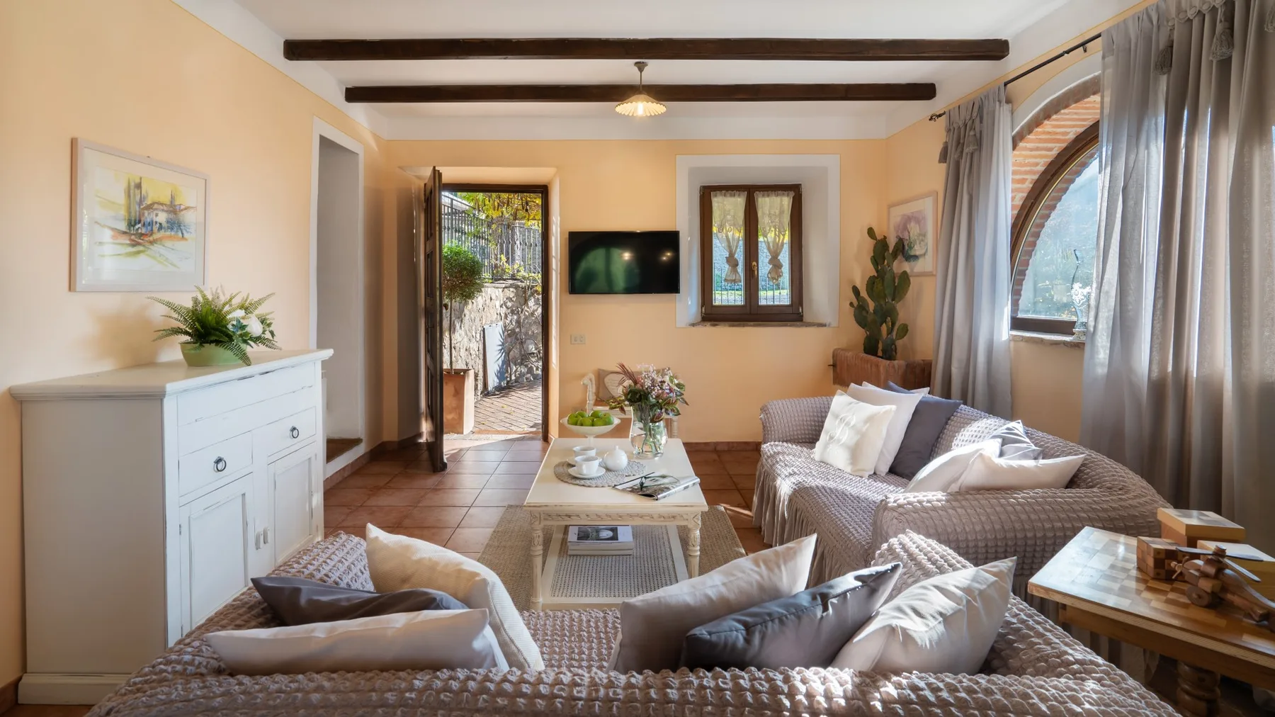 Una sala luminosa con asientos, una mesa de centro y una puerta abierta.