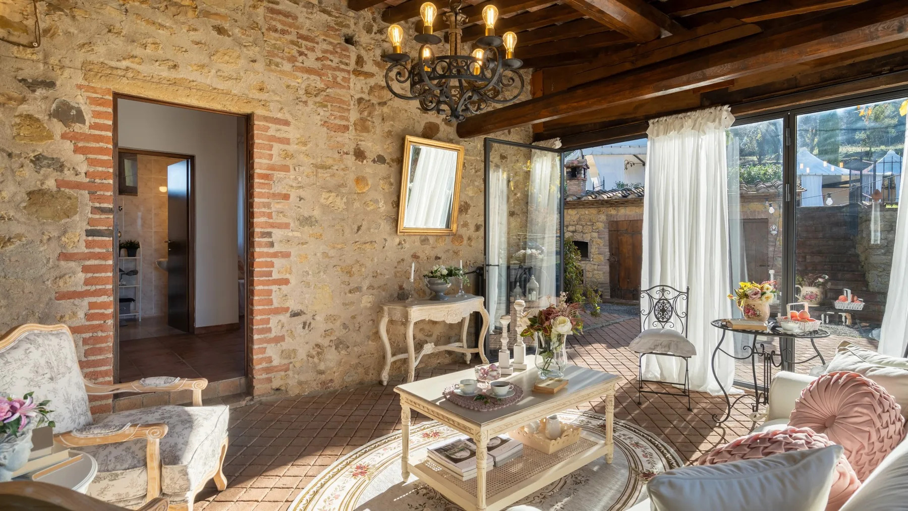 Una sala de estar rústica con paredes de piedra vista y asientos alrededor de una mesa de centro.