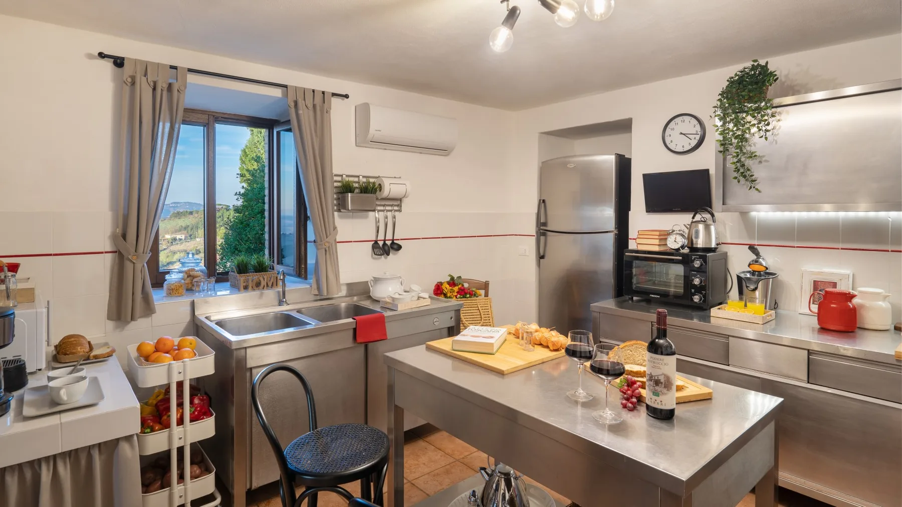 Una cocina luminosa con una isla central y una ventana con vistas a la vegetación.