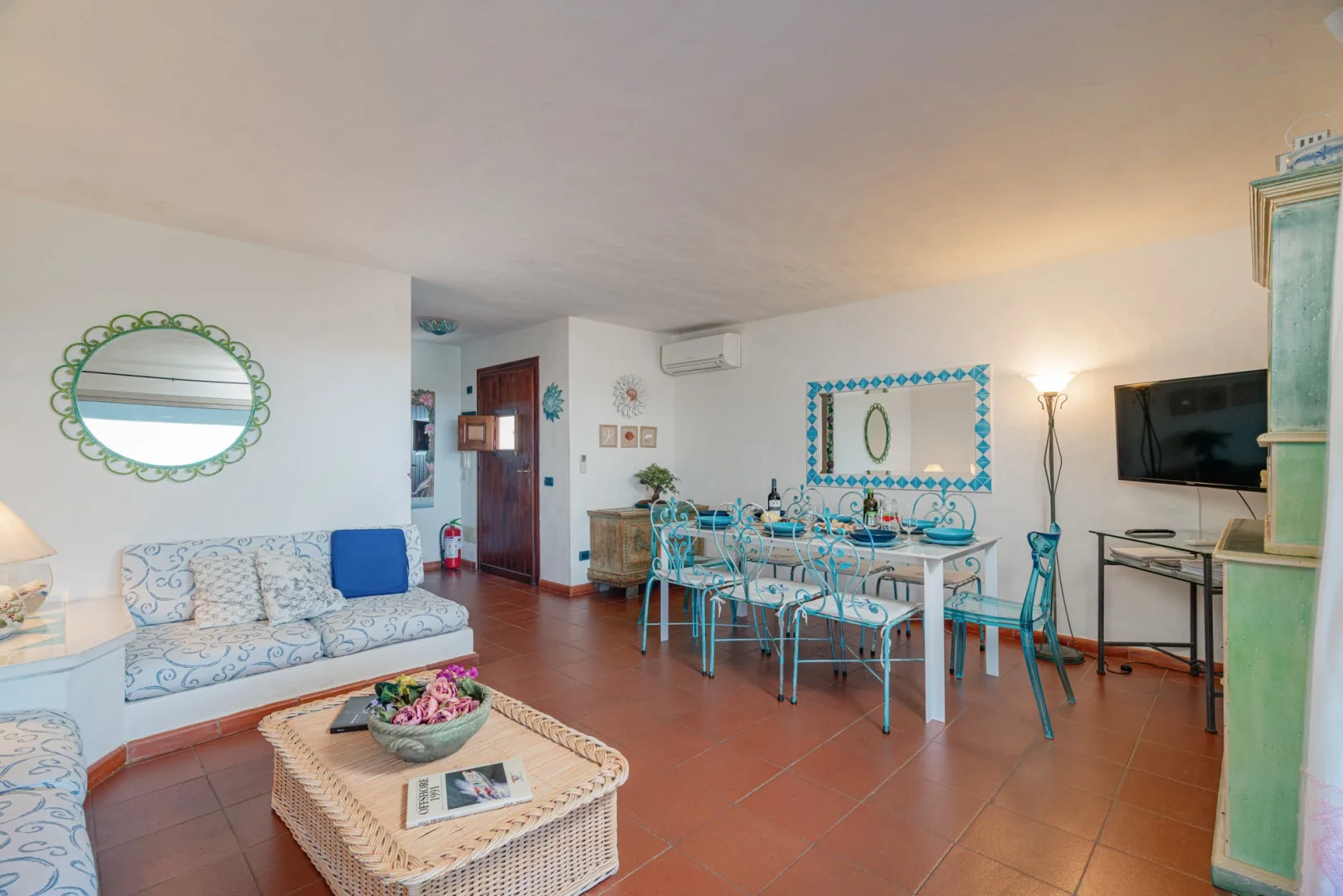 A living and dining area with a patterned seating set and a table.