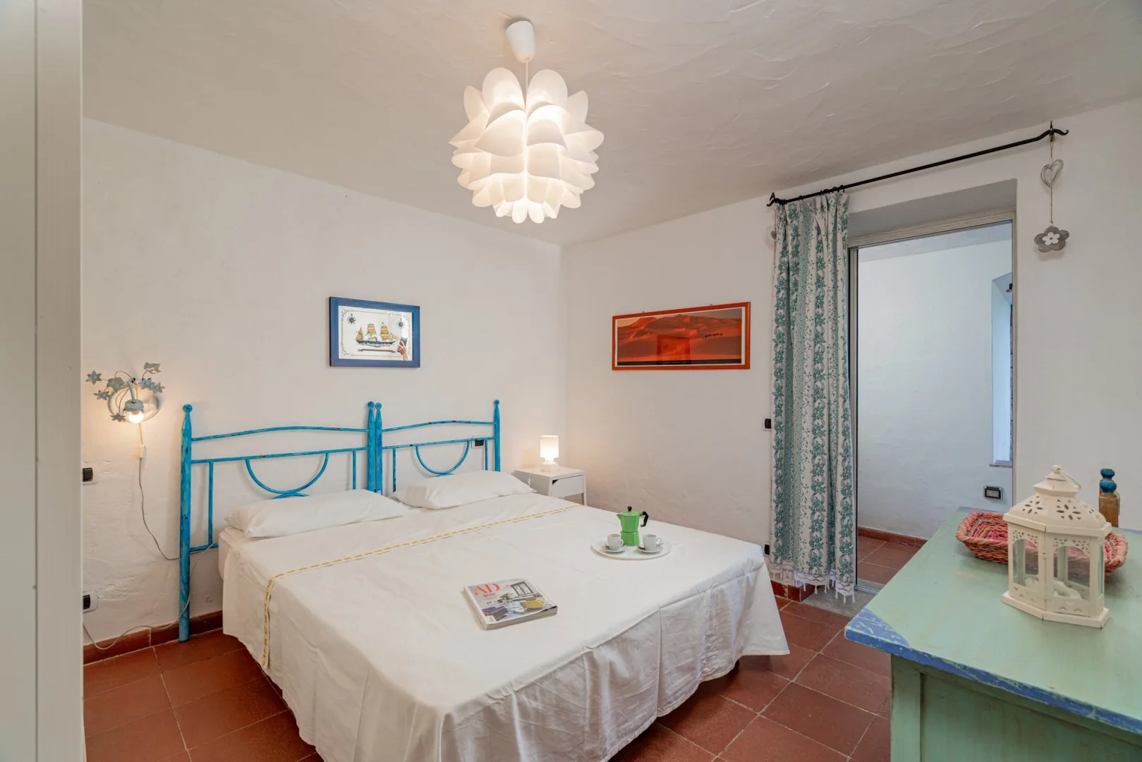 A bedroom with a double bed and an open doorway to an adjoining room.