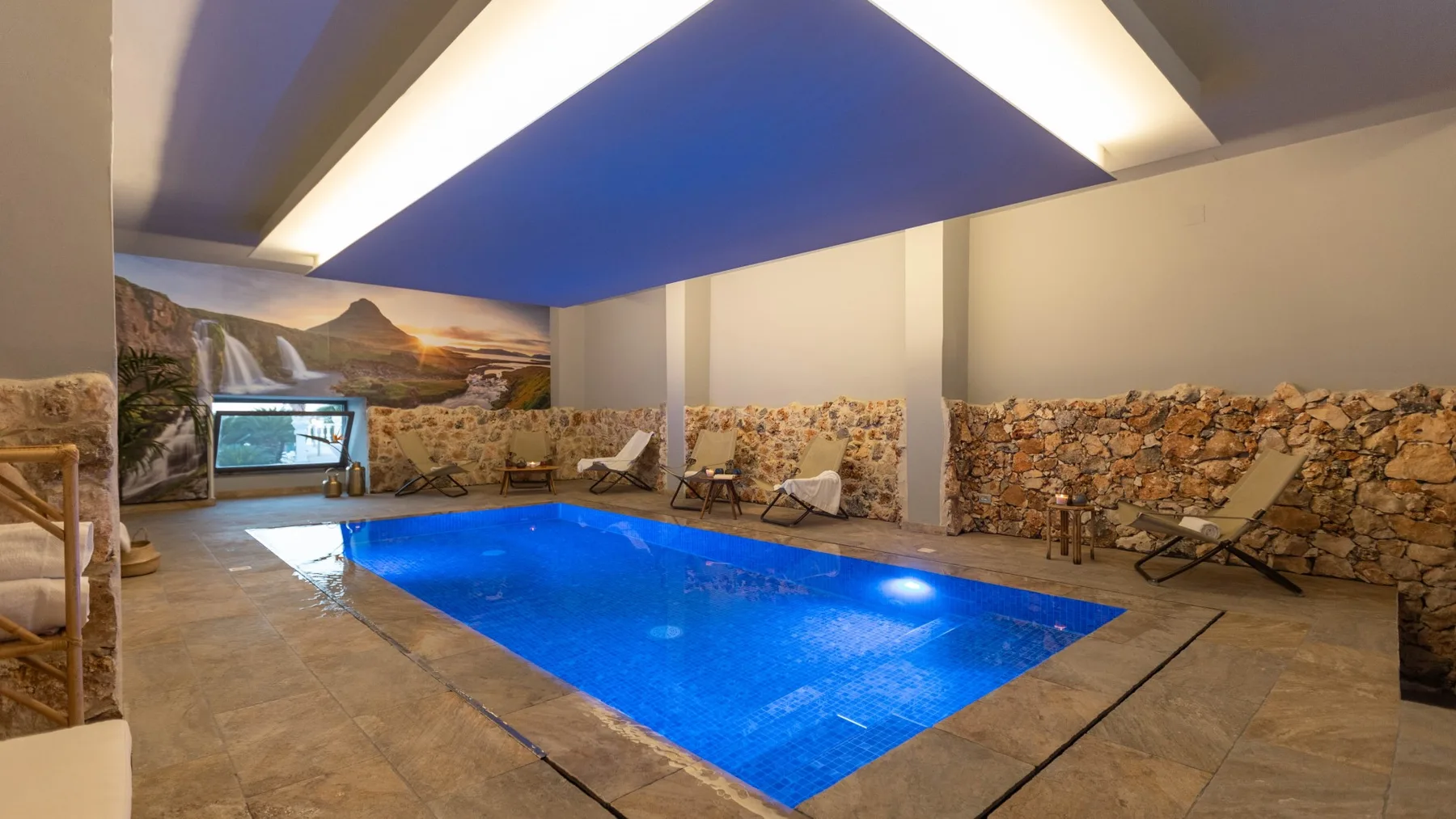 Una piscina cubierta está rodeada de paredes de piedra y asientos.