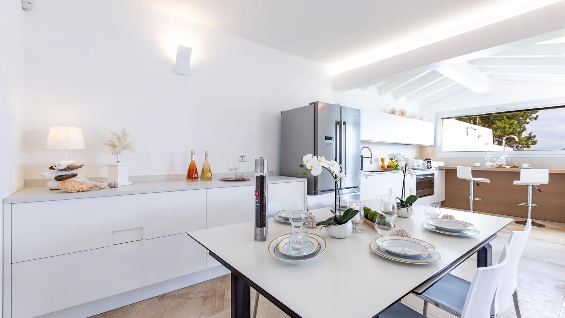 Una cocina luminosa con una mesa de comedor puesta con vajilla.