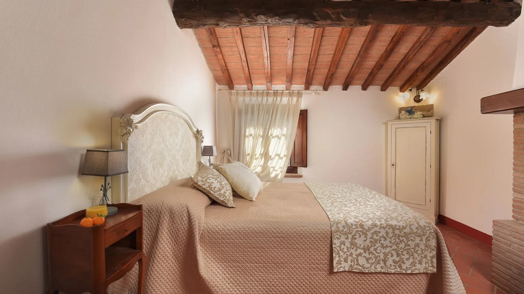 Un dormitorio con una cama grande bajo un techo de madera inclinado.