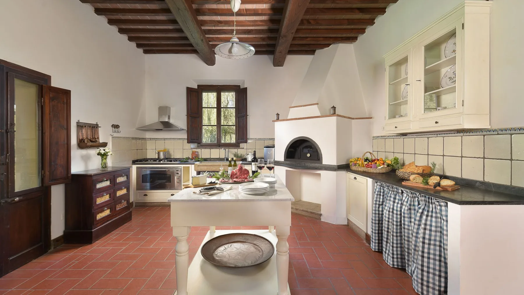 Una cocina luminosa con una isla central y vigas de madera expuestas en el techo.