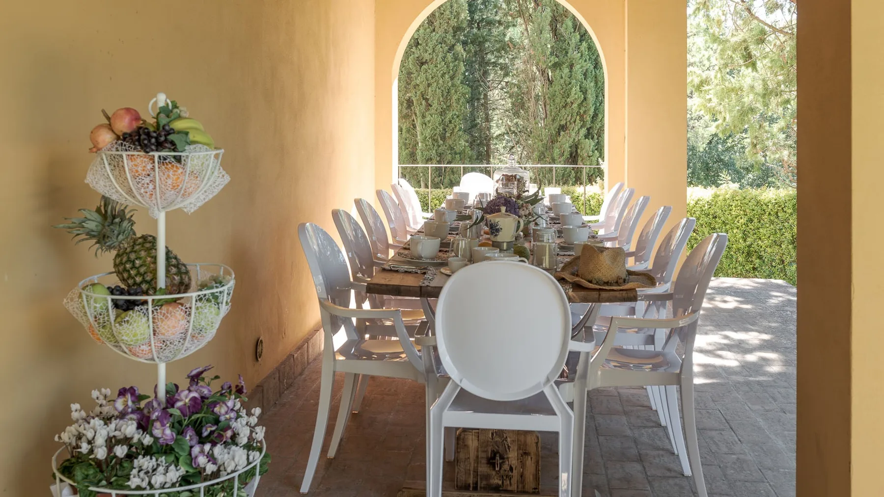 Comedor con una mesa larga puesta junto a una ventana arqueada.