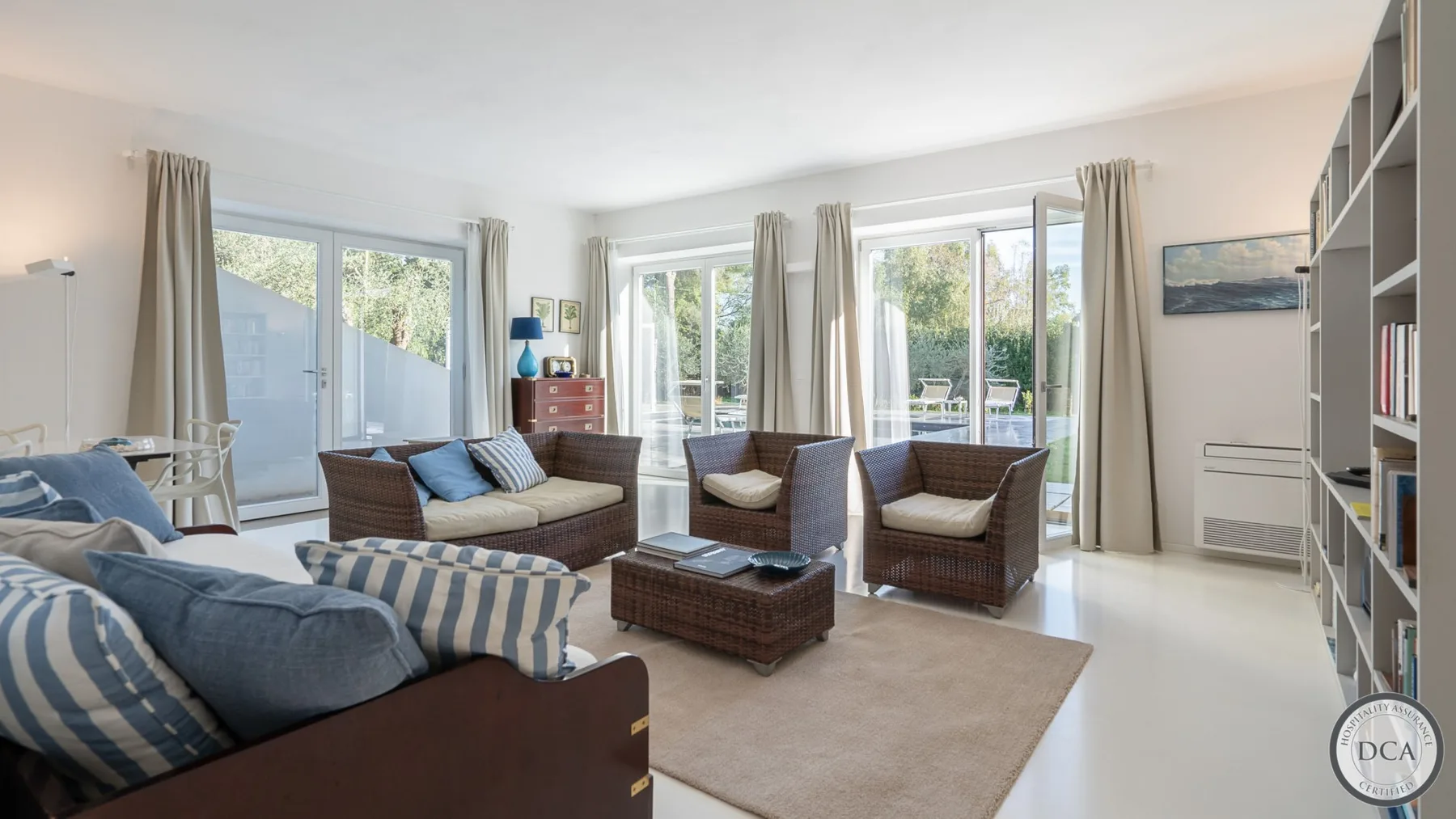 A bright living room with seating around a low coffee table and large windows.