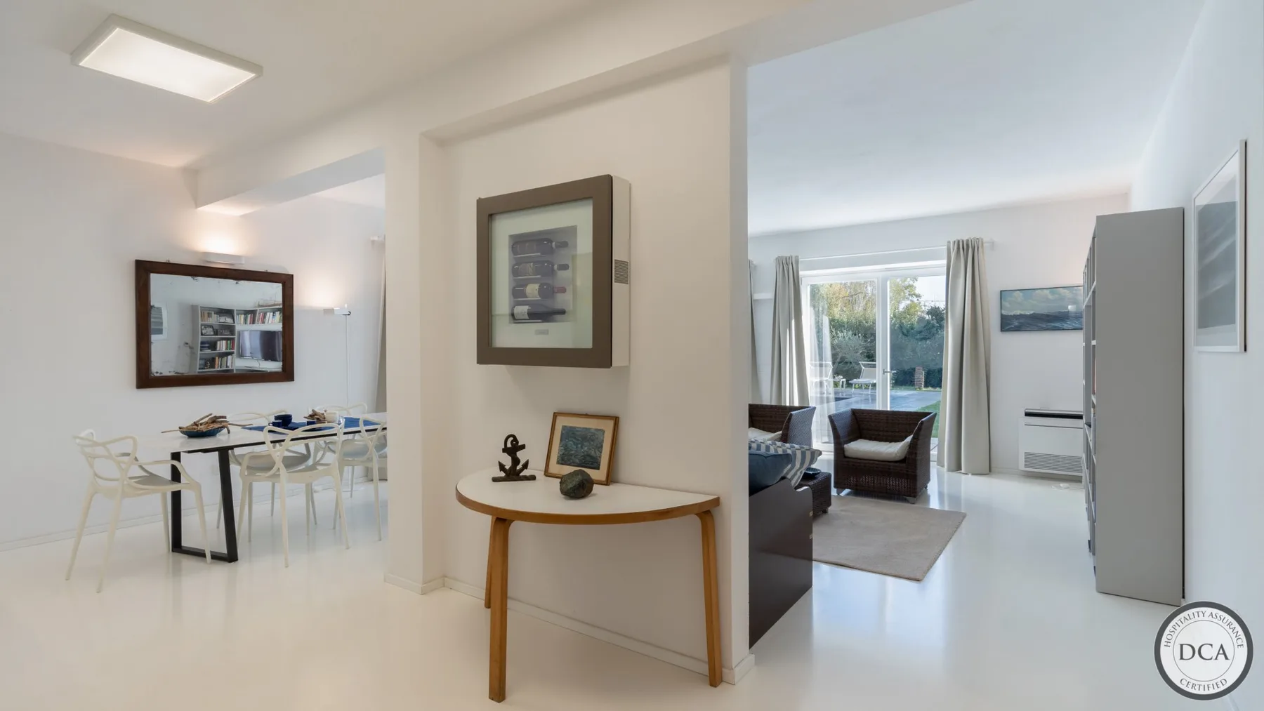 A bright open-plan living and dining area with a table and seating by the windows.