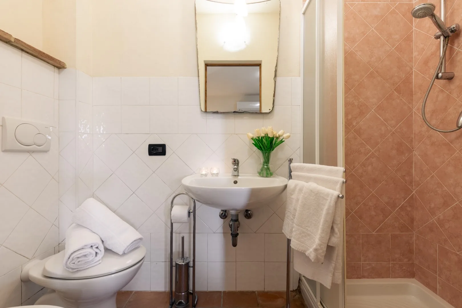 A bathroom with a sink, toilet, and tiled shower area.