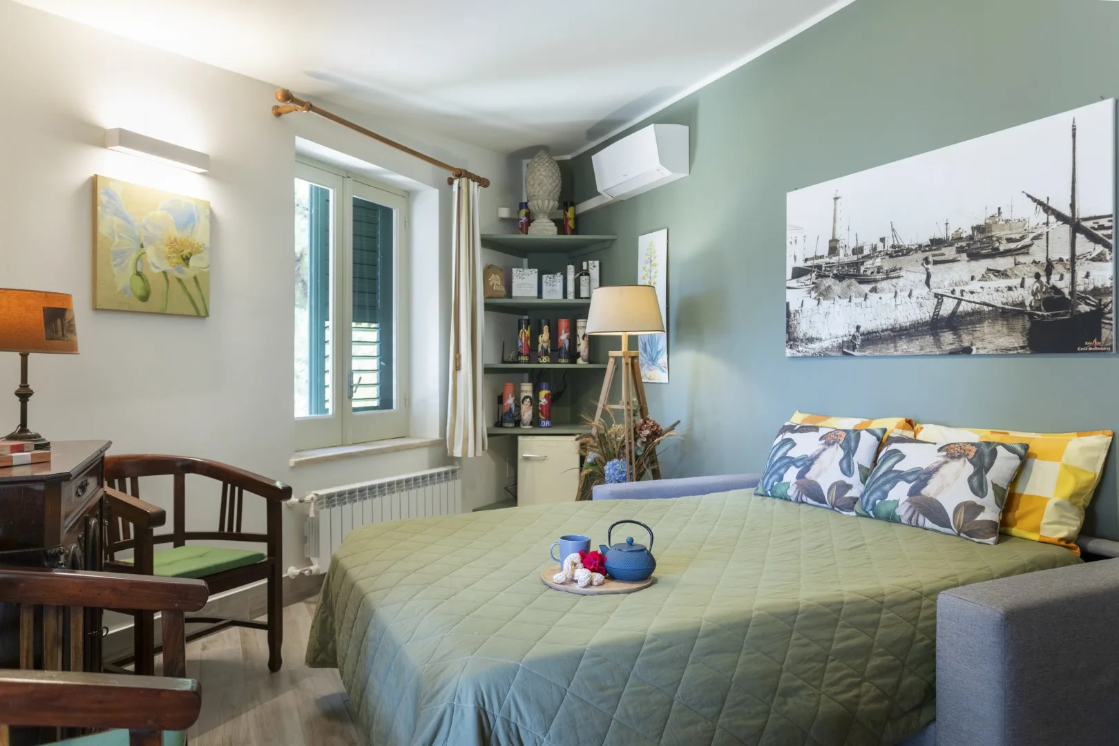 Un dormitorio con una cama grande, cojines coloridos y una ventana.