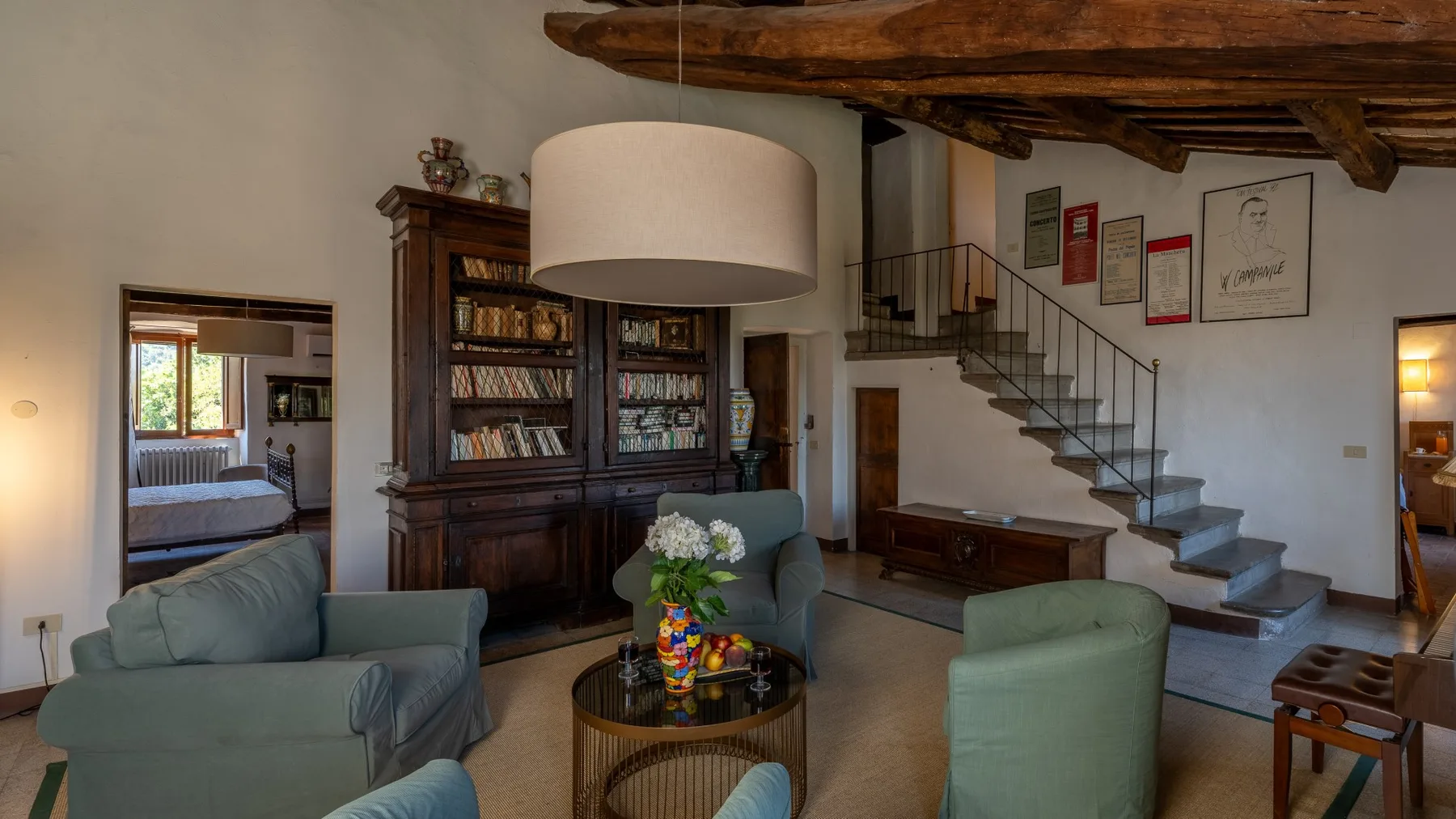 A living room with seating around a coffee table and a staircase along the wall.