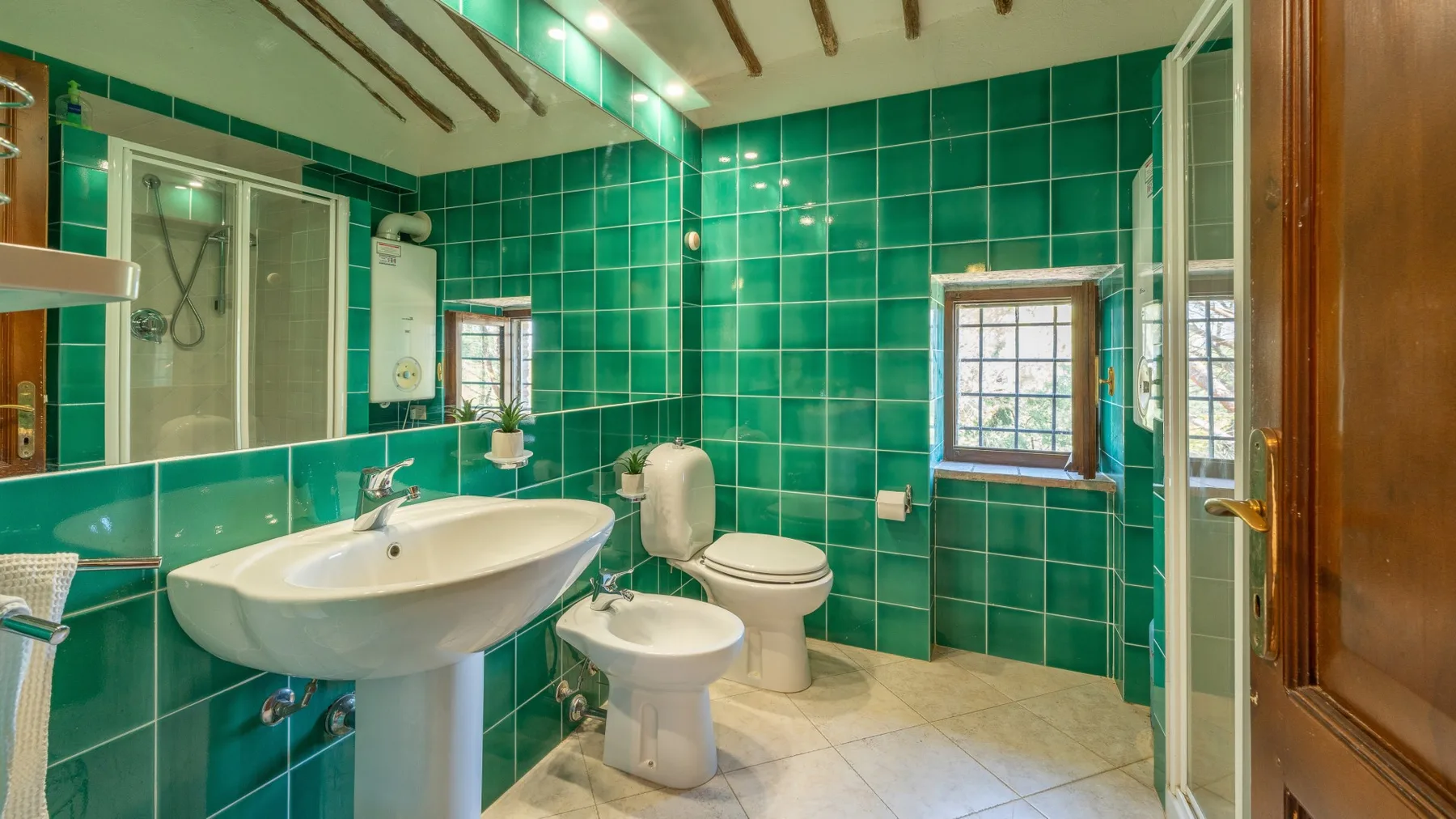 A tiled bathroom with a sink, toilet, and shower.