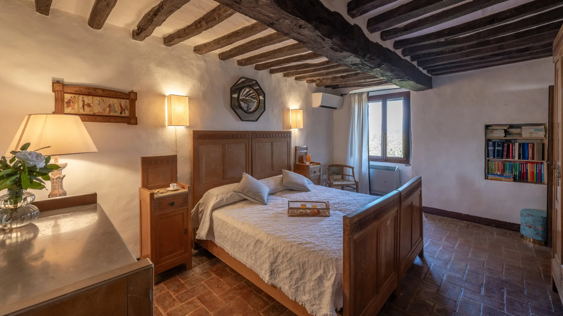 A bedroom with a wooden bed, bedside tables, and exposed ceiling beams.