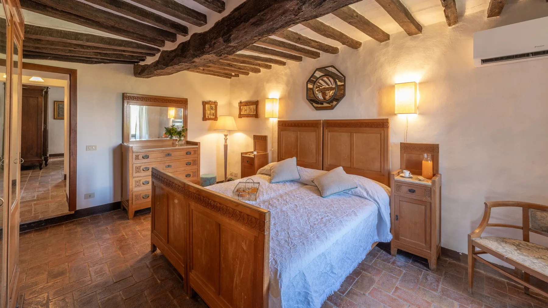 A bedroom with a wooden bed, bedside tables, and exposed ceiling beams.