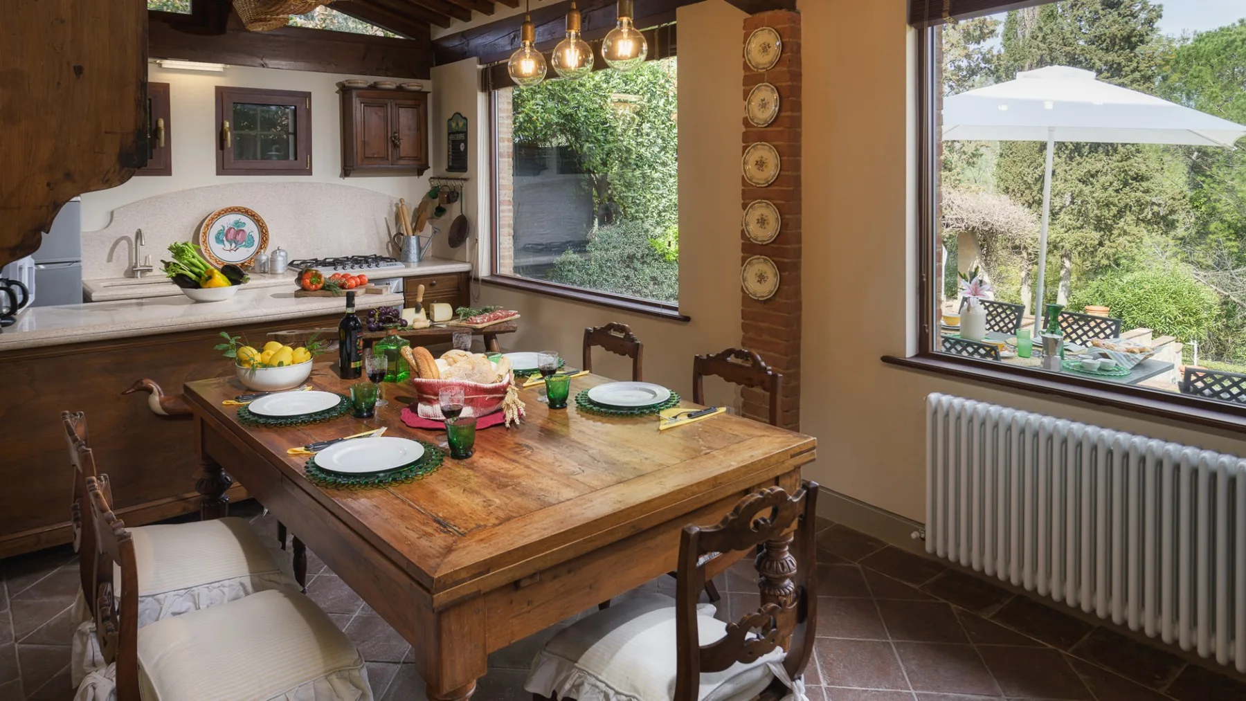 Comedor con una mesa de madera preparada para comer junto a grandes ventanas.