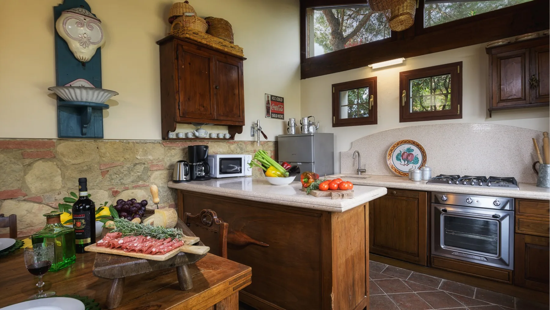 Una cocina rústica con gabinetes de madera, una isla central y electrodomésticos sobre la encimera.
