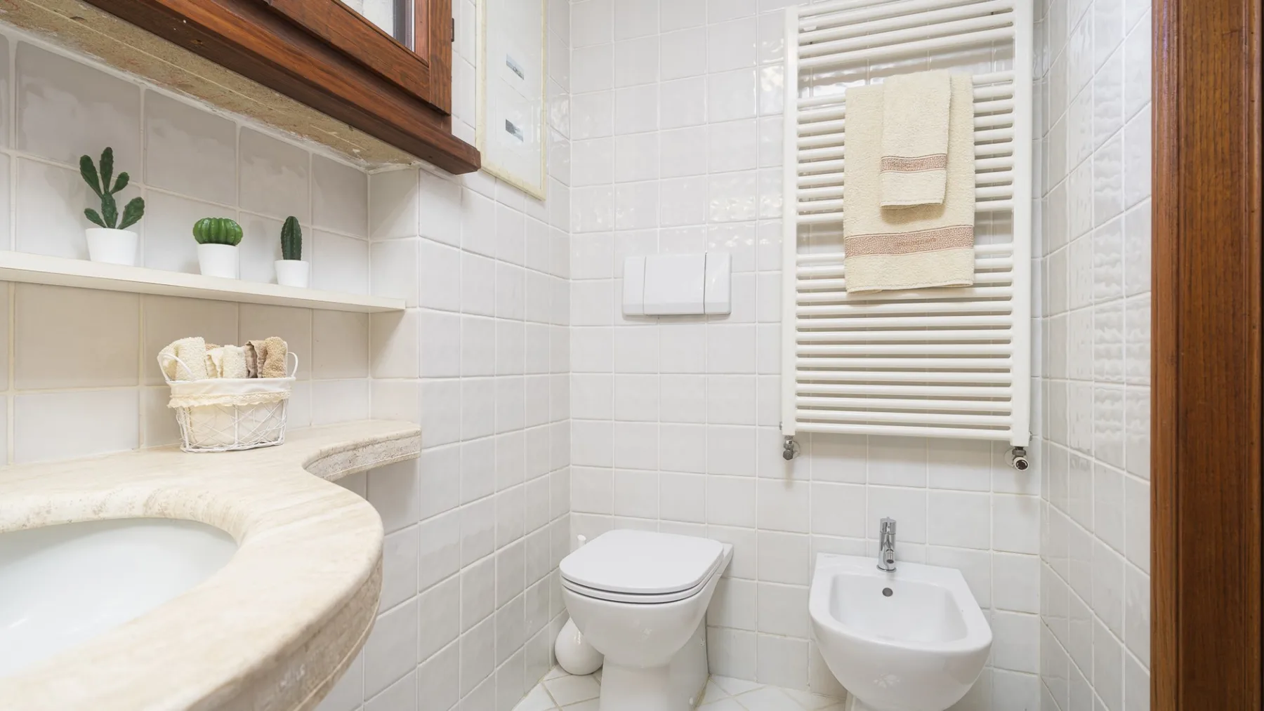 Un baño alicatado con lavabo, inodoro, bidé y toallero calefactable.