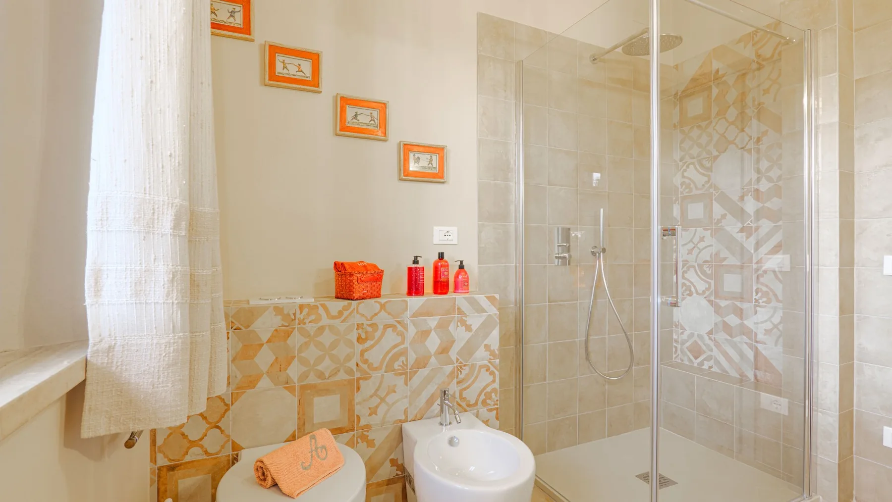 A tiled bathroom with a glass shower and a sink.