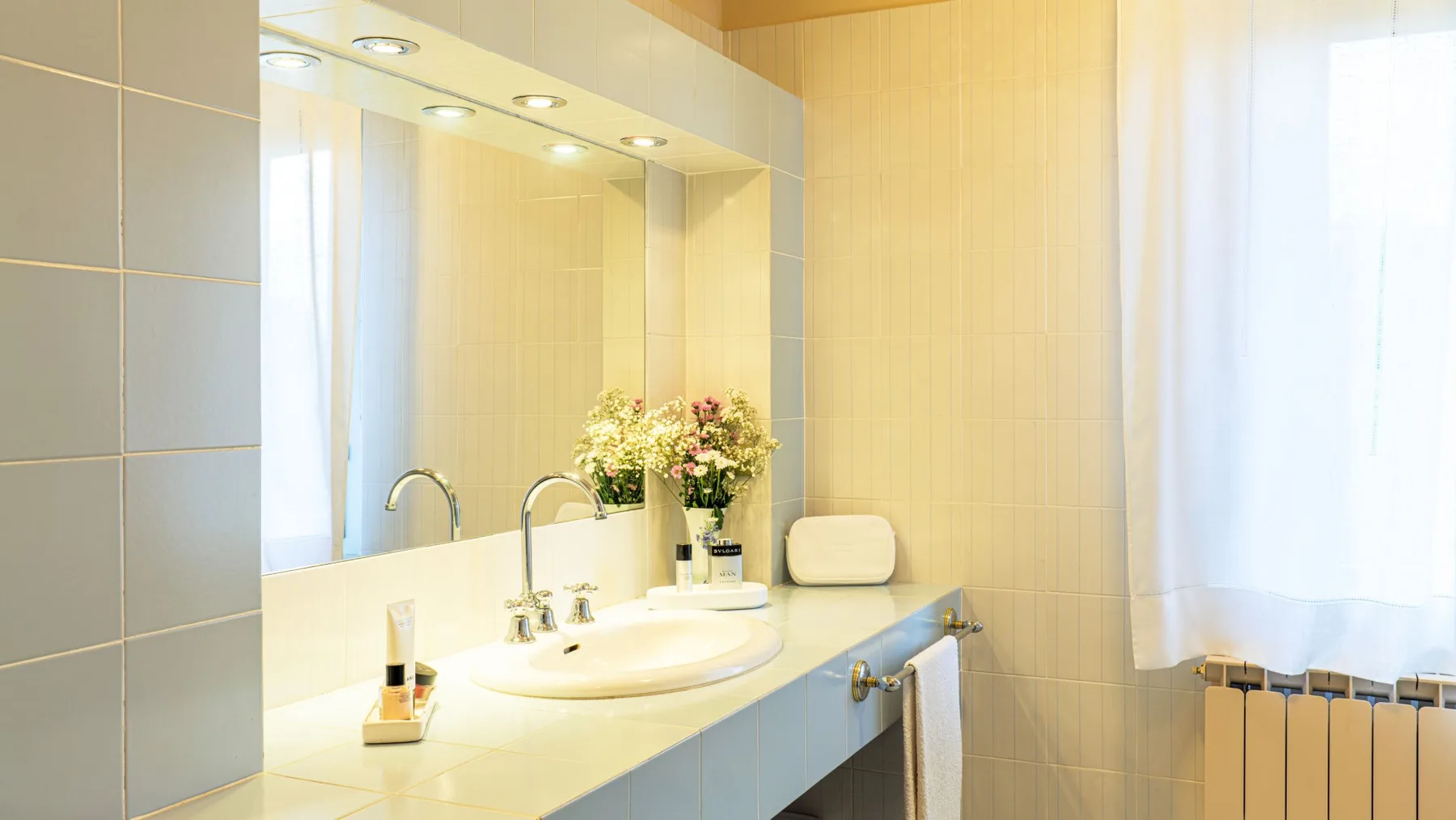 A bathroom vanity with a sink and large mirror.