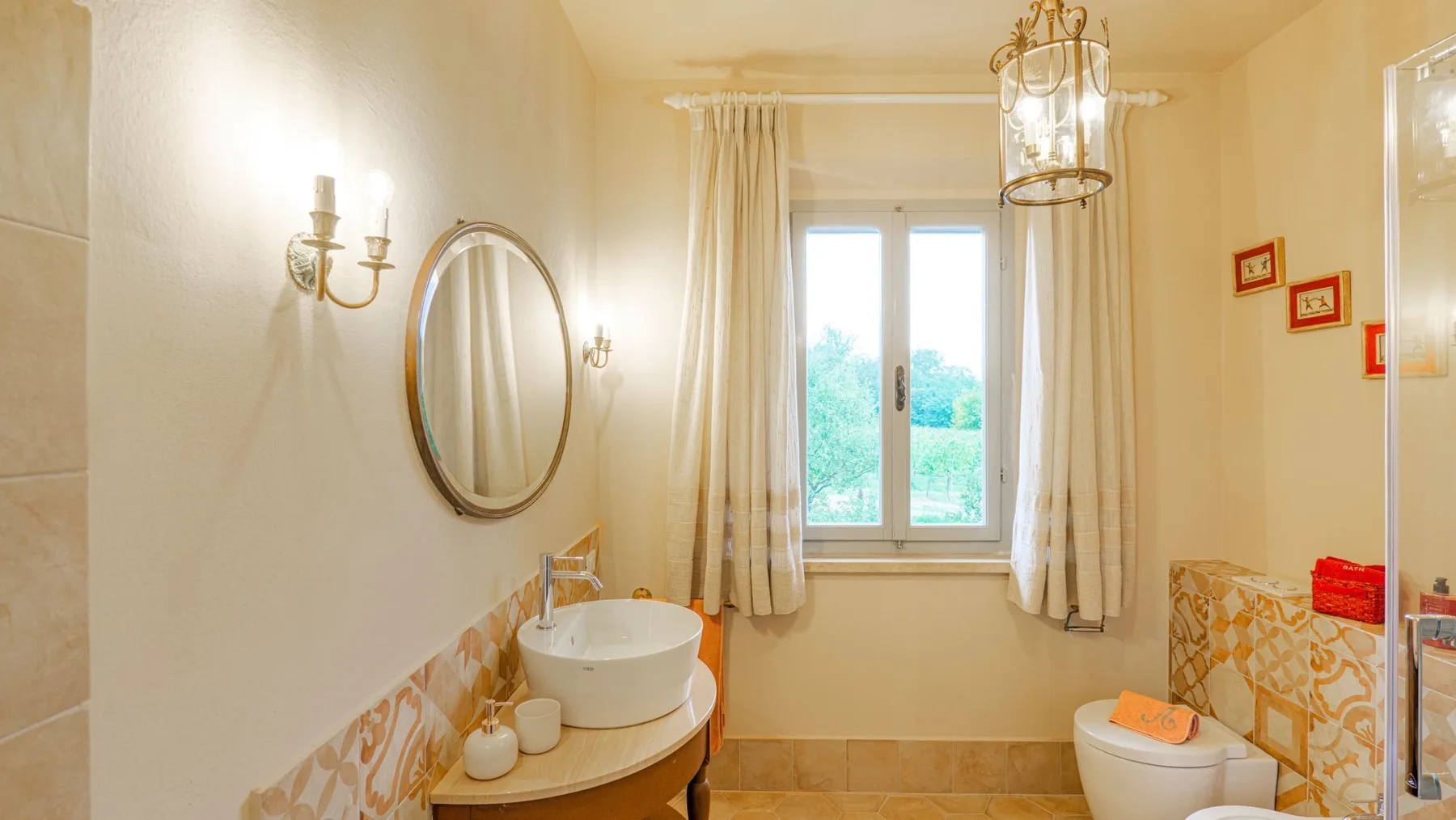 A bright bathroom with a sink, toilet, and window.