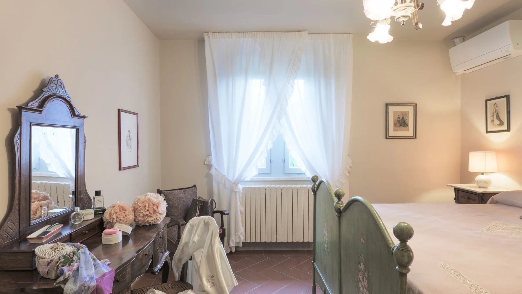 A bedroom with a bed beside a curtained window and radiator.