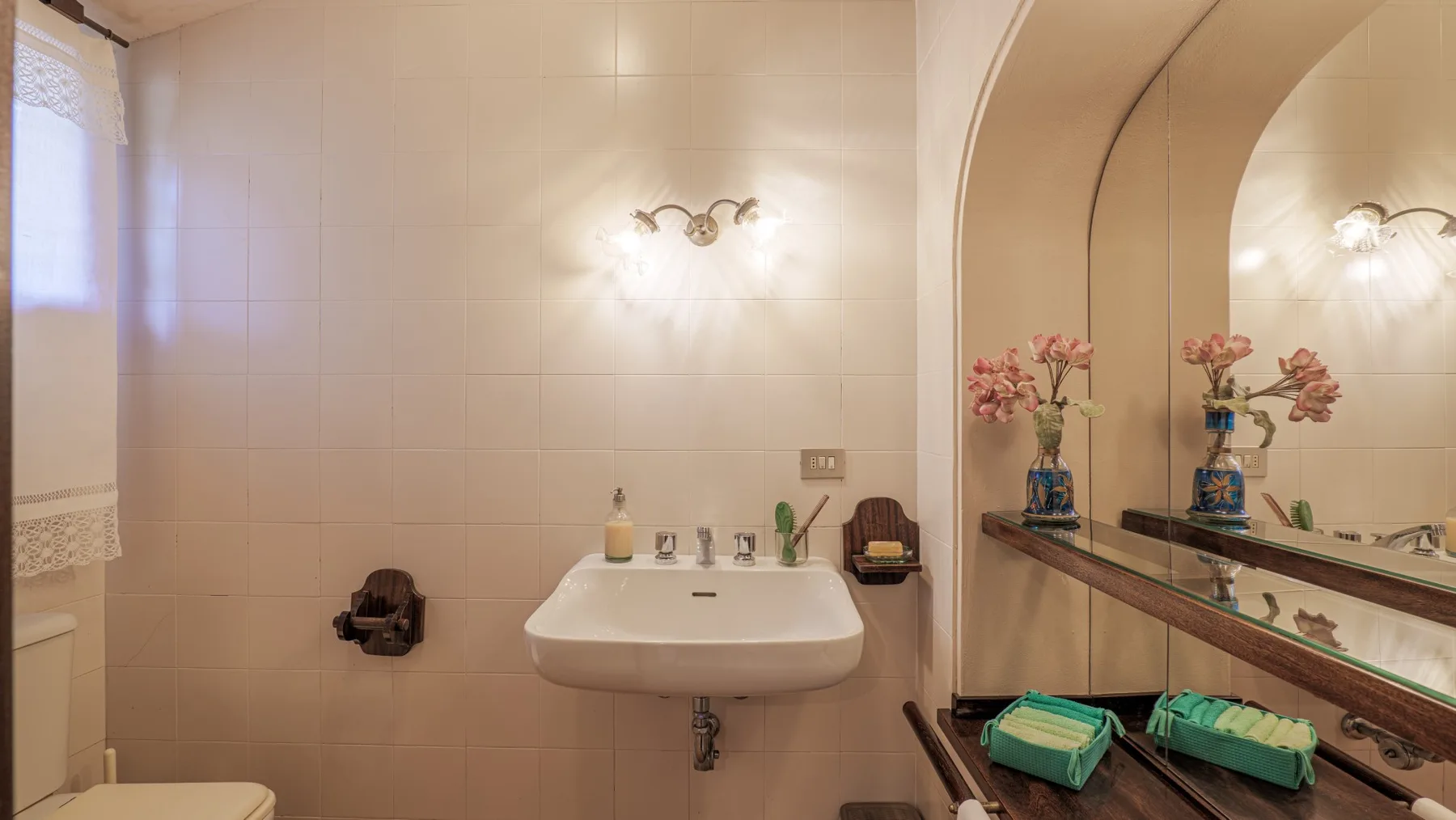 A bathroom with a wall-mounted sink and a large mirror.