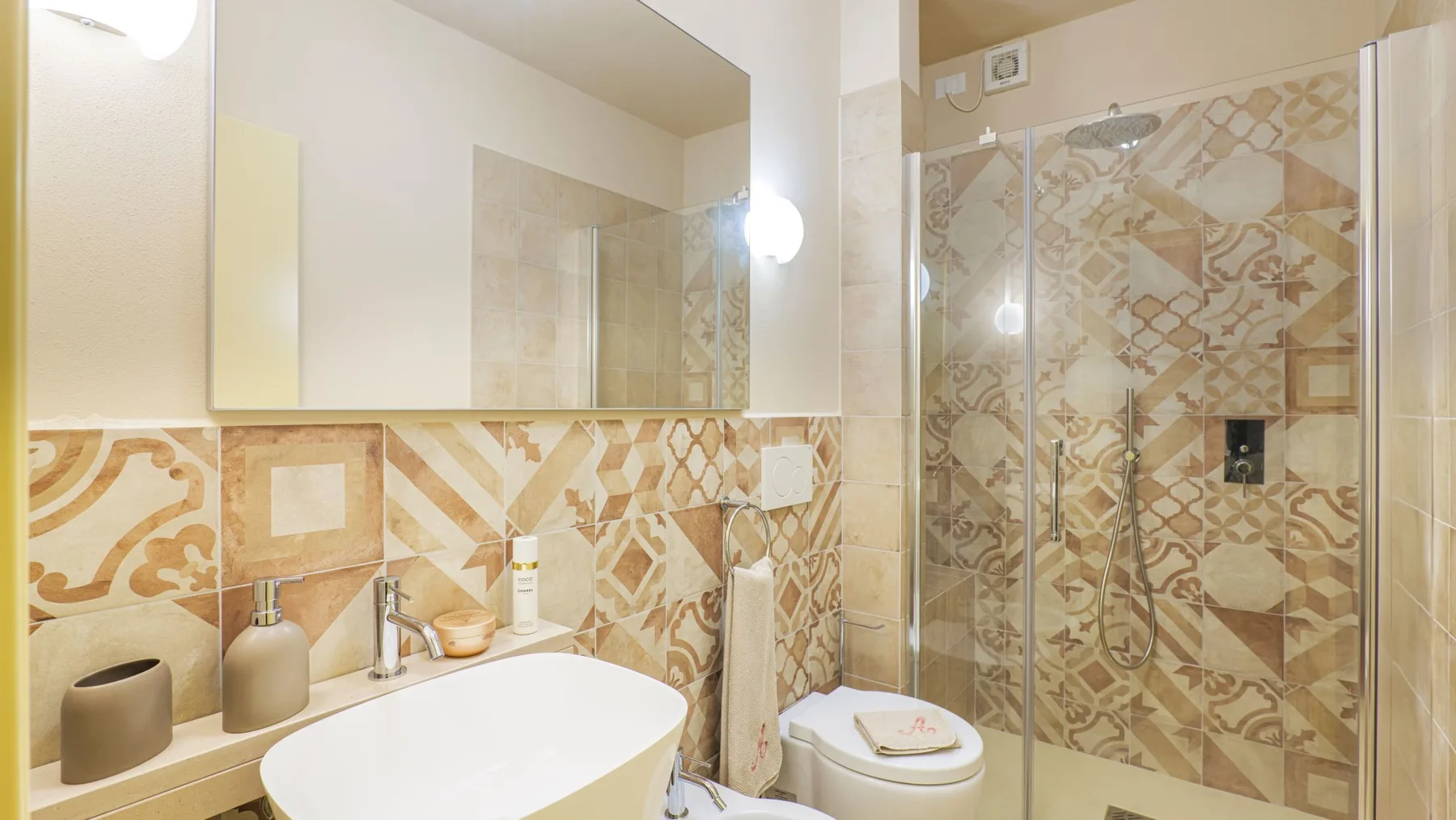 A bathroom with a sink, toilet, and glass-enclosed shower.