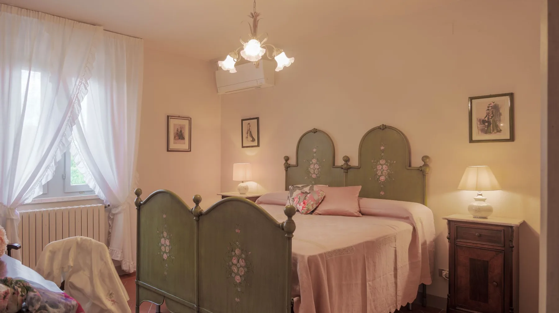 A bedroom with a large bed, matching headboard, and softly lit bedside tables.