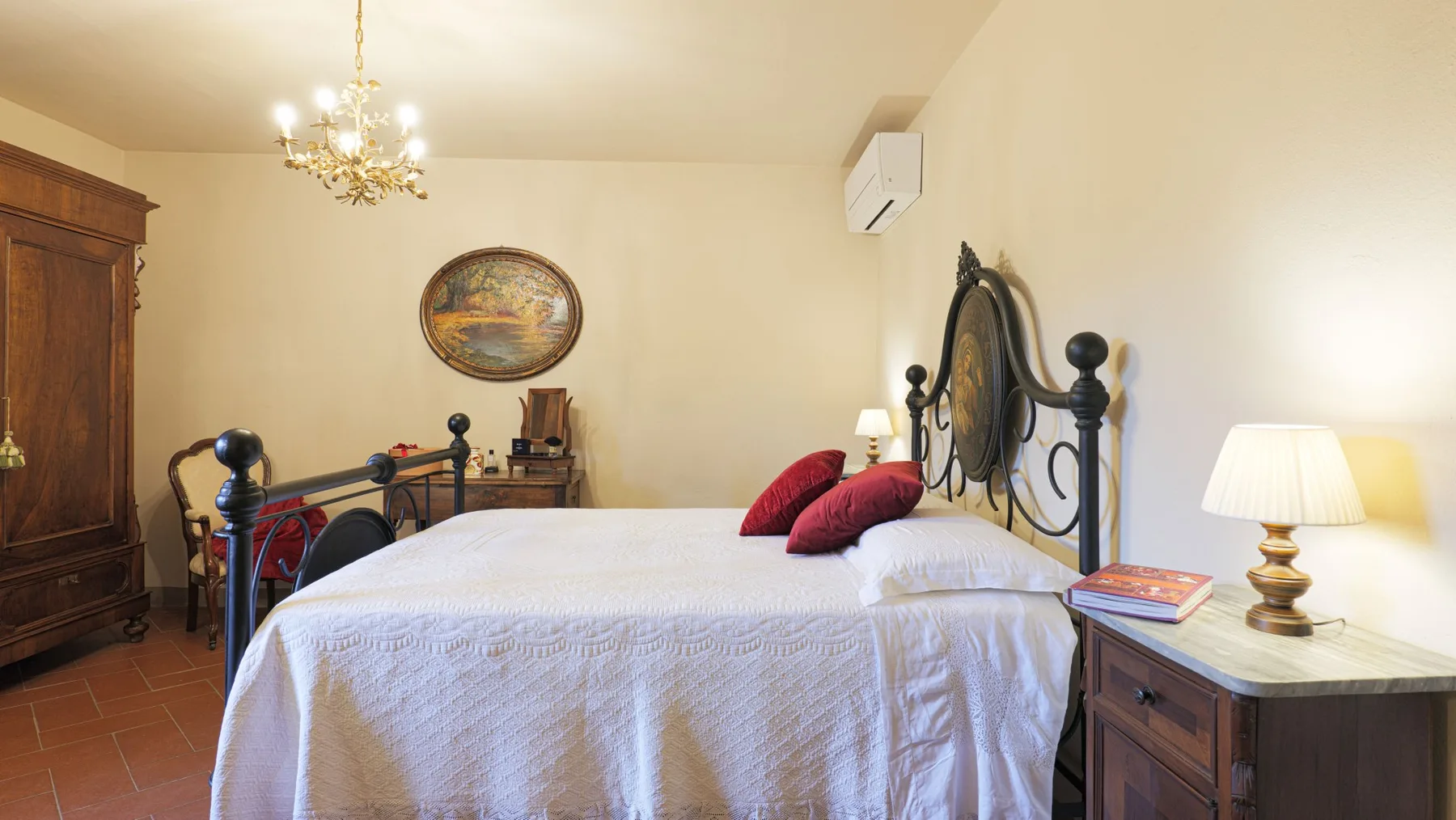 A bedroom with a bed, dark metal headboard, and bedside table.