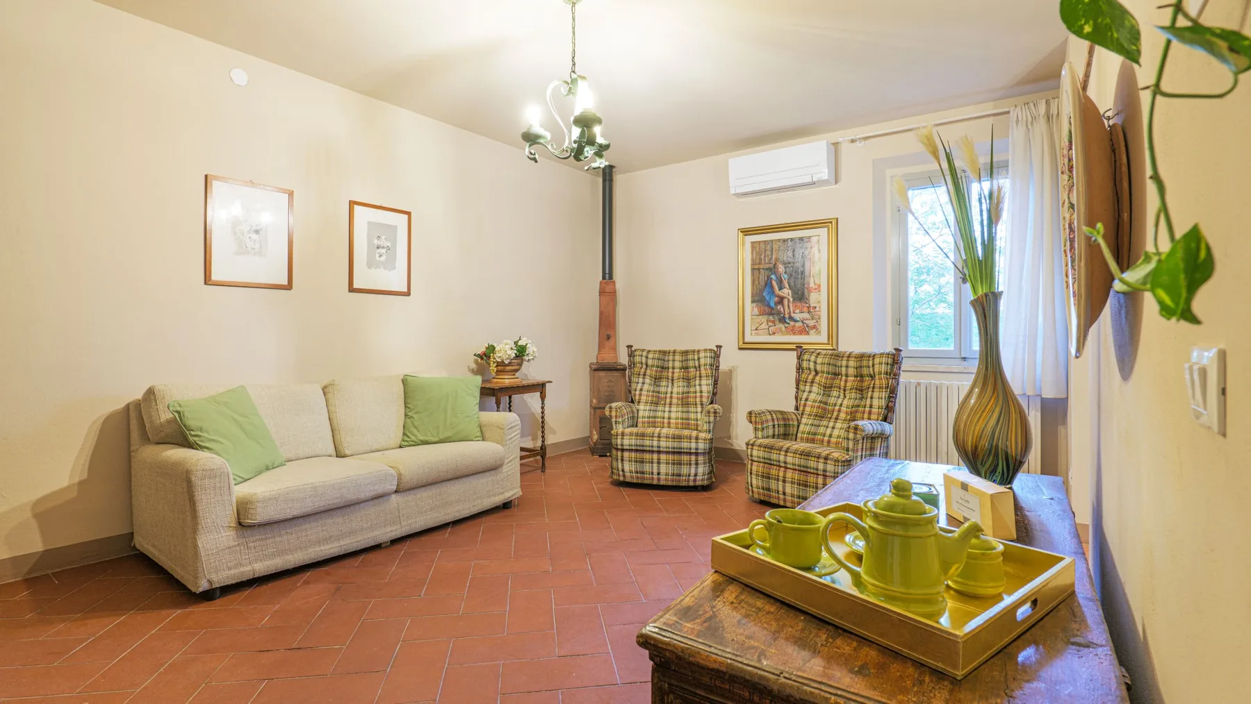 A living room with a sofa and two plaid armchairs around a coffee table.