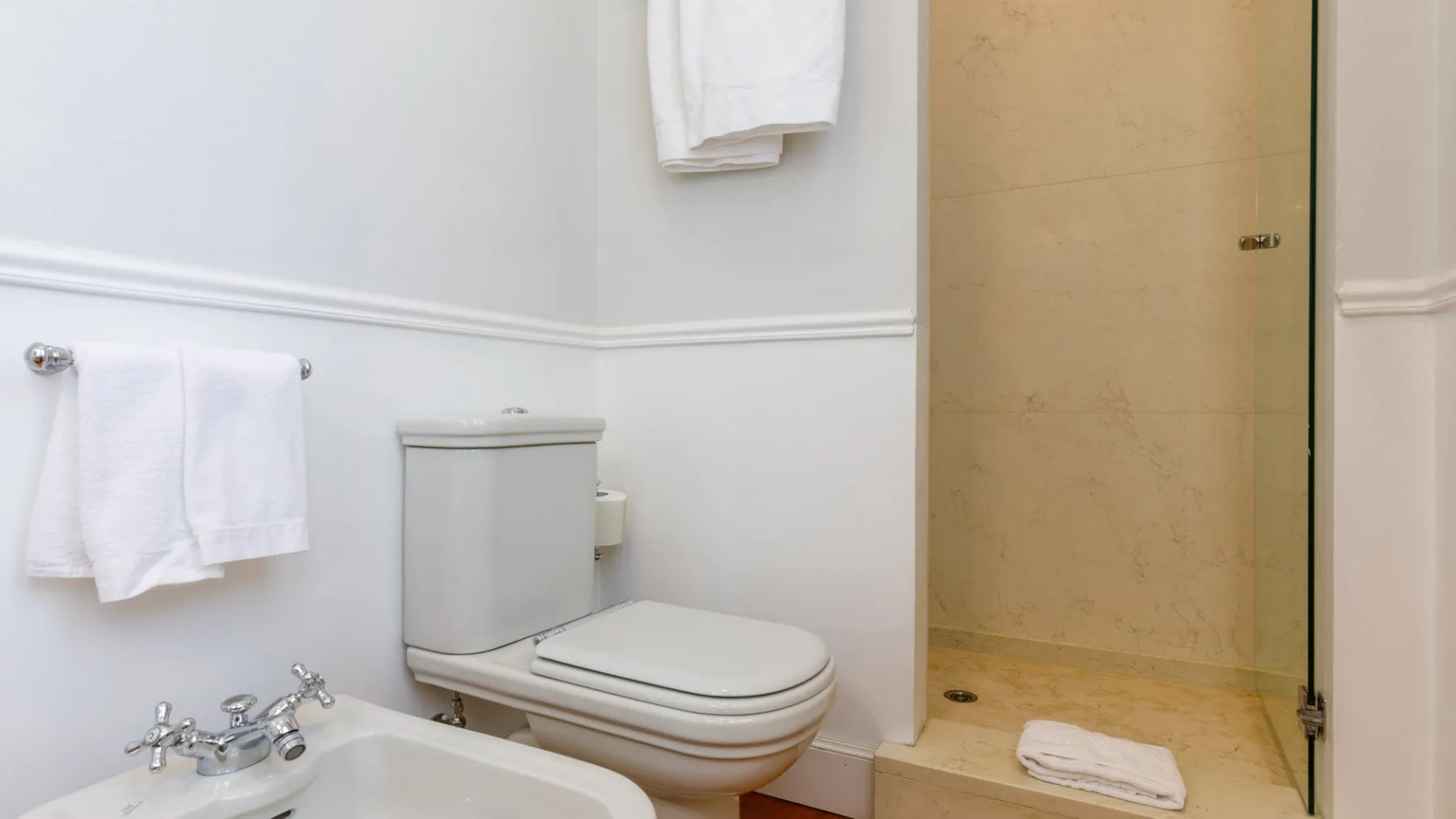 Un baño con inodoro, lavabo y ducha.