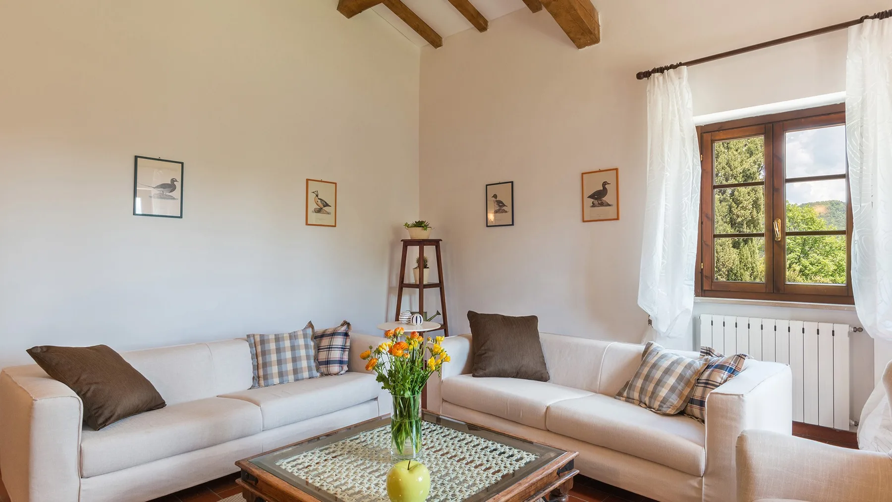 Una luminosa sala de estar con asientos claros y una mesa de centro de madera.