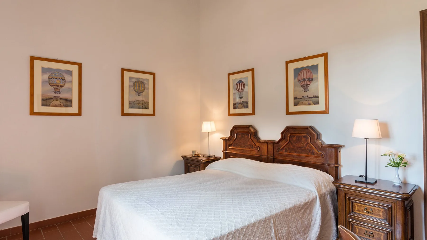 Un dormitorio con una cama grande, un cabecero de madera y cuadros en la pared.