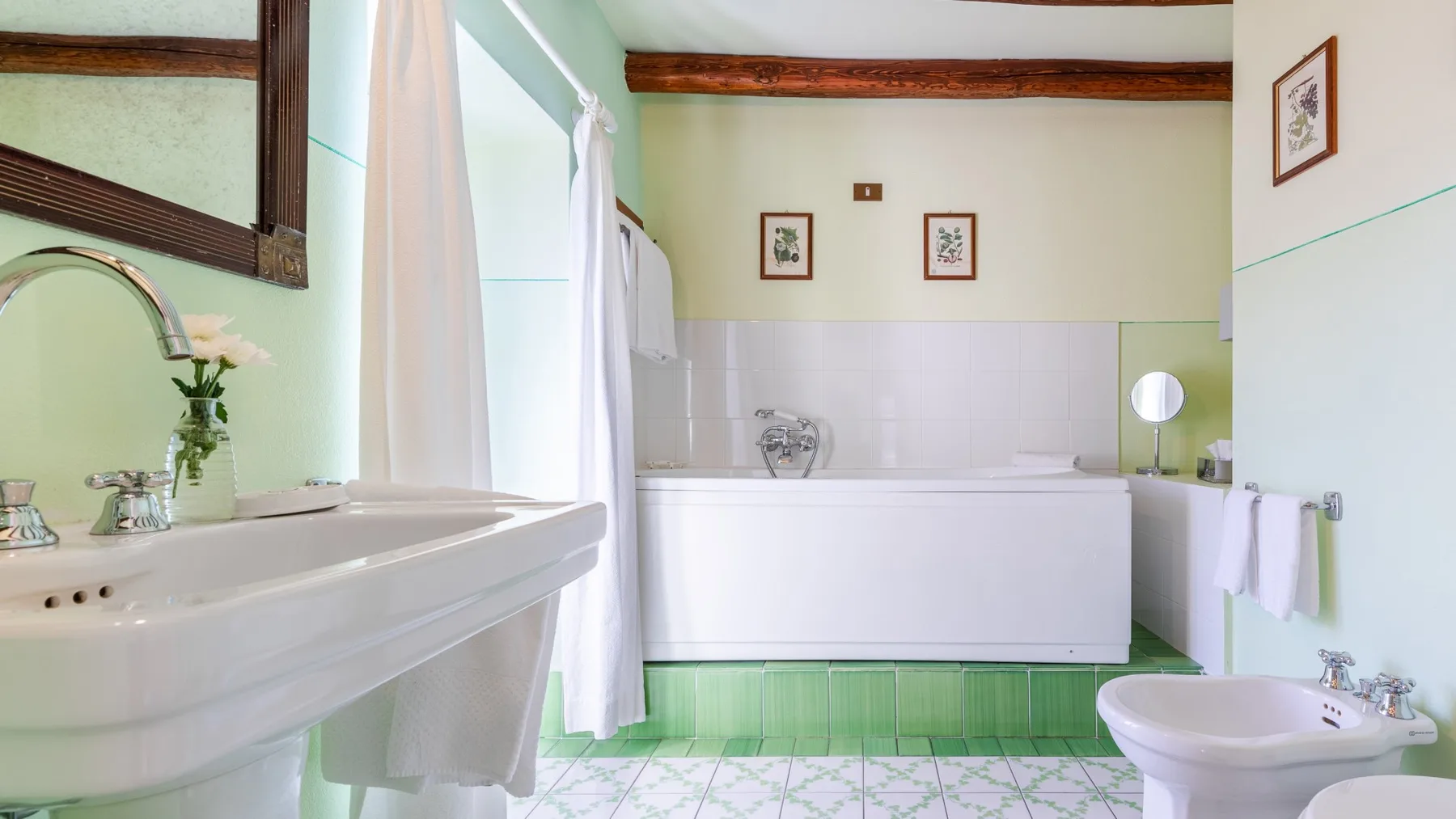 A bright bathroom features a bathtub, sink, and green floor tiles.