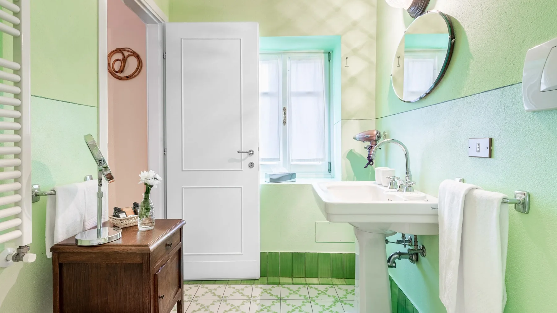 A bright bathroom with a sink, mirror, and window.