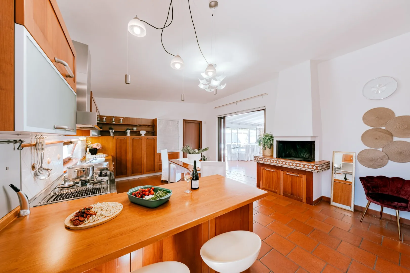 A bright kitchen and dining area with a long counter and a table by the windows.