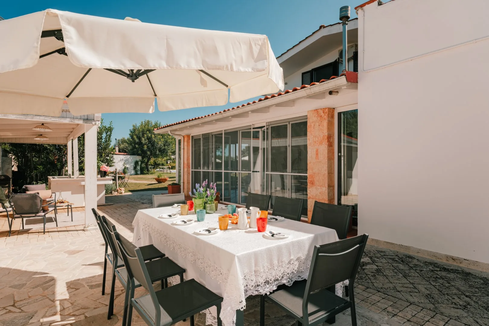 An outdoor dining area with a table beneath white umbrellas.