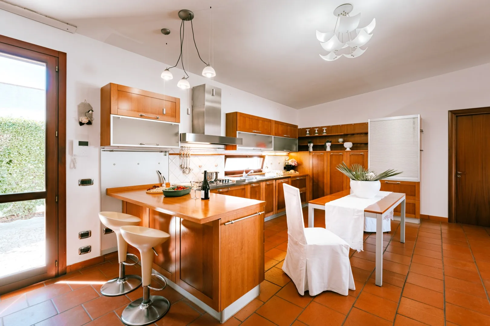 A bright kitchen and dining area with wooden cabinets and a central island.