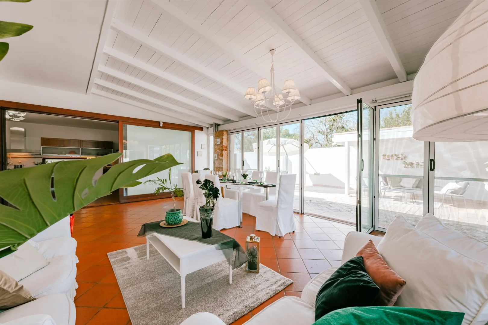 A bright living and dining area opens onto a patio through large glass doors.