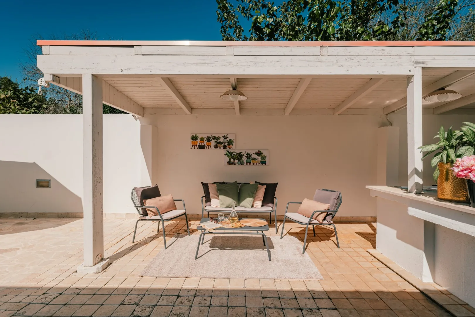 A covered outdoor patio with seating and a low table.