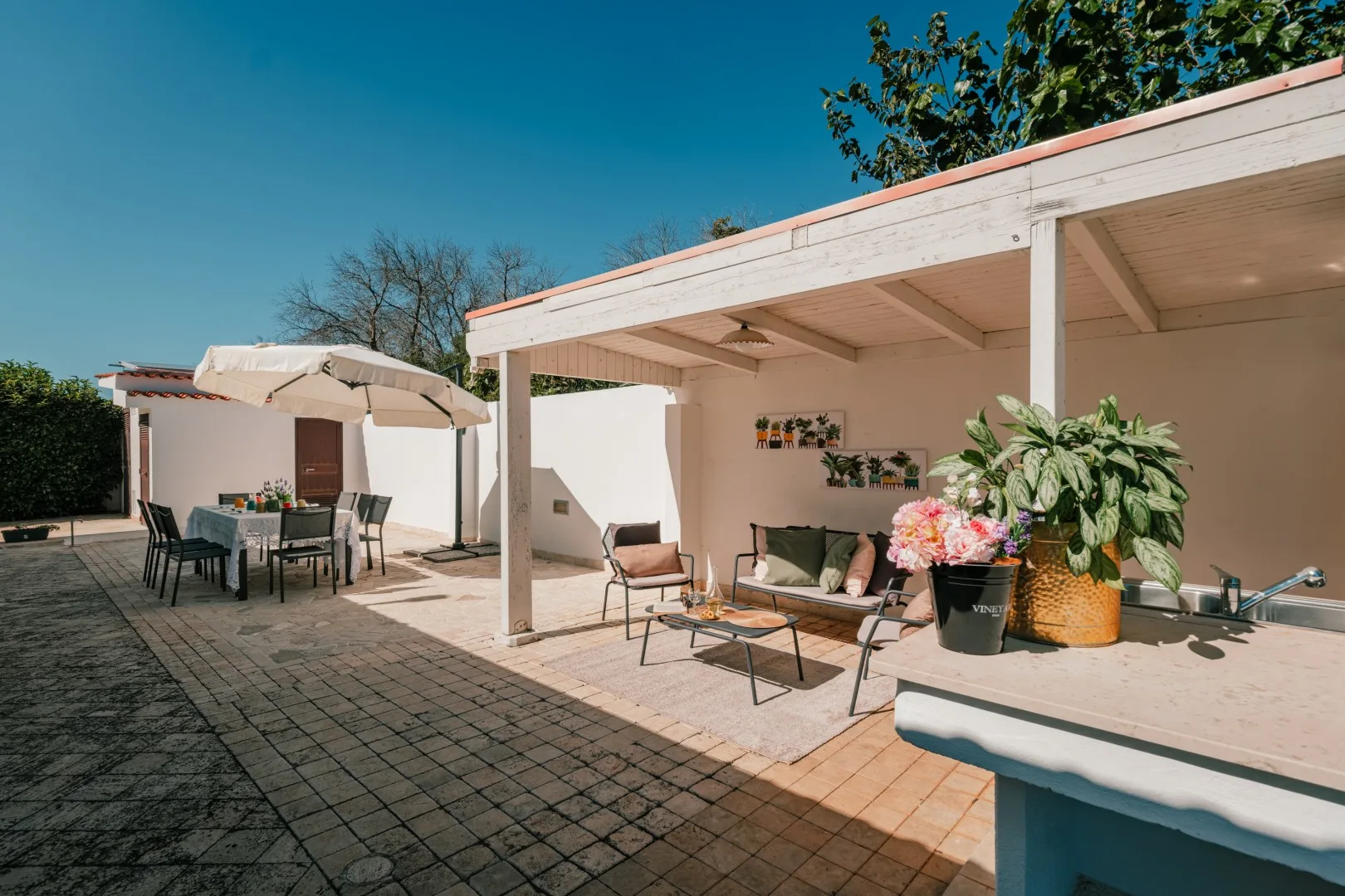 A sunlit patio with a shaded seating area and an outdoor dining table.