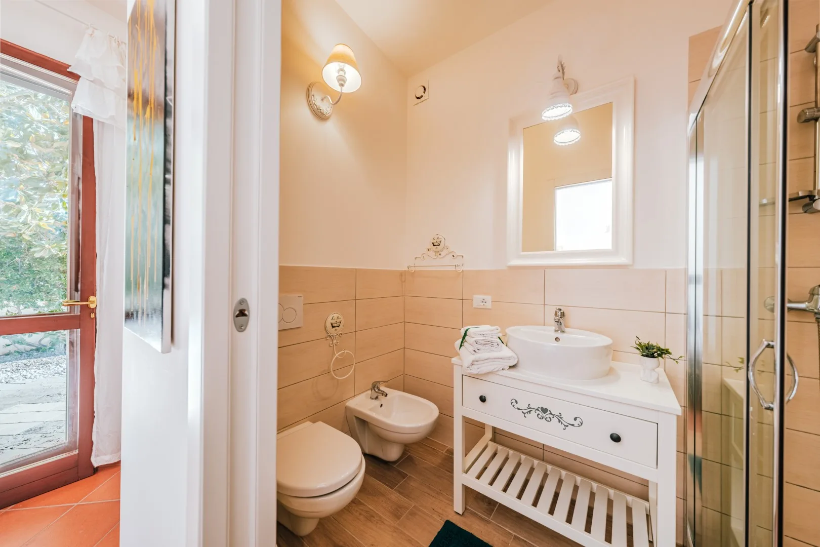 A bathroom with a sink, toilet, and glass shower enclosure.